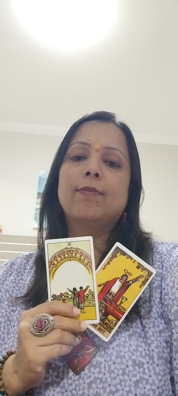 Yaashashrie holding 10 of Cups and The Magician Tarot cards